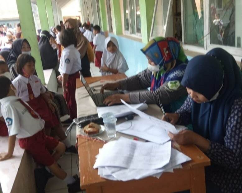 TENANG. Petugas mendata anak sekolah yang akan menjalani vaksinasi Covid-19 di salah satu sekolah dasar di Kabupaten Majalengka, Kamis (13/1).