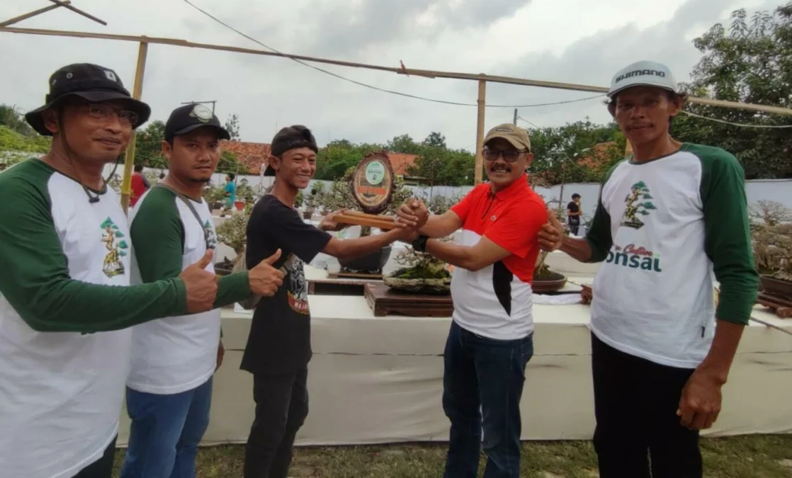 PEMENANG. Ketua DPRD Indramayu Syaefudin (kanan) menyerahan hadiah kepada pemenang kontes bonsai. Sebanyak 411 tanaman bonsai dipamerkan oleh para penggemar bonsai.