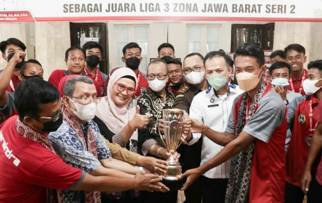 ANGKAT TROPHY. Bupati Indramayu Nina Agustina (ketiga kiri) mengangkat trophy Juara Liga 3 Seri 2 Jabar bersama pemain, pelatih, dan official Persindra Indramayu. Nina juga menyerahkan langsung uang pembinaan sebagai bentuk apresiasi atas prestasi yang telah diukir Persindra.