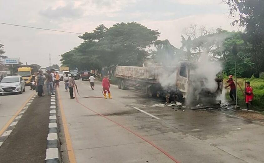 DIPADAMKAN. Sejumlah petugas pemadam kebakaran memadamkan api yang membakar kabin truk trailer di jalur Pantura Indramayu. Insiden ini dikabarkan tidak memakan korban luka maupun nyawa.