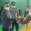 BERHADIAH MIGOR. Kades Kramatmulya Otong Sutisna didampingi Kapolsek Iptu Dede Ksunadi menyerahkan minyak goreng gratis kepada warga yang sudah divaksin Covid-19 di Balai Desa Kramatmulya, kemarin.