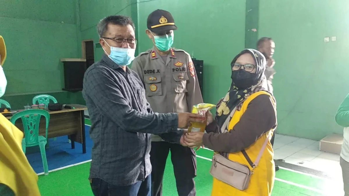 BERHADIAH MIGOR. Kades Kramatmulya Otong Sutisna didampingi Kapolsek Iptu Dede Ksunadi menyerahkan minyak goreng gratis kepada warga yang sudah divaksin Covid-19 di Balai Desa Kramatmulya, kemarin.