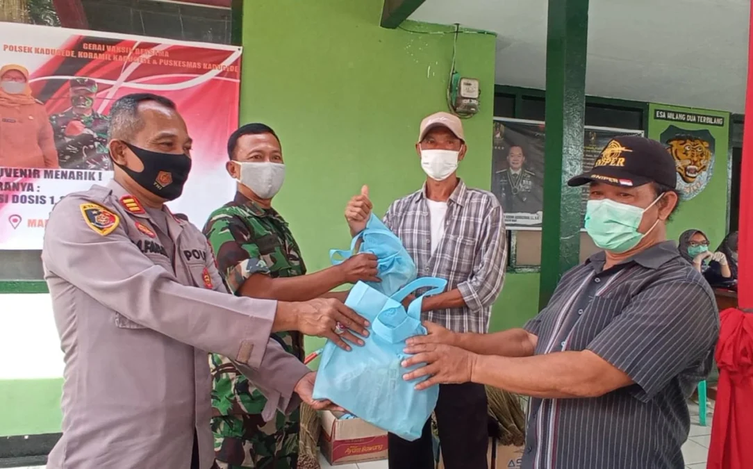 DAPAT SUVENIR. Polsek Kadugede, Koramil 1502/Kadugede dan Puskesmas Kadugede menggelar gerai vaksin bersama berhadiah suvenir menarik berupa alat-alat kebersihan rumah tangga.