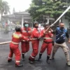 CAIRAN DISINFEKTAN. Petugas Damkar melakukan penyemprotan cairan disinfektan di kompleks perkantoran Setda Kuningan, akhir pecan kemarin