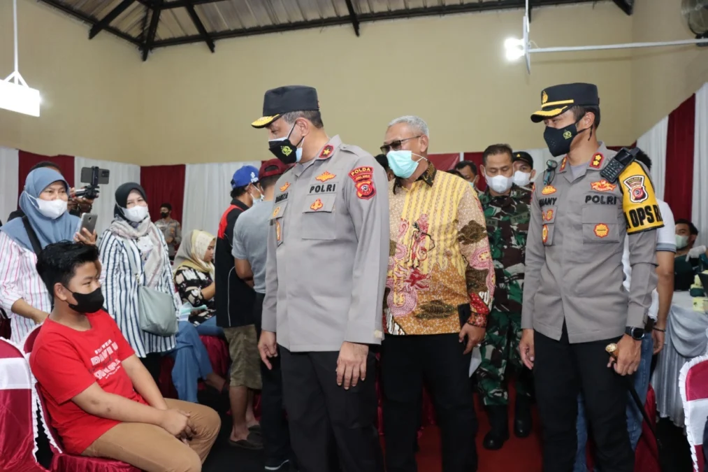 PANTAU VAKSINASI. Wakapolda Jabar Brigjen Pol Bariza Zulfi SIK melihat langsung pelaksanaan vaksinasi massal serentak di Balai Desa Sangkanhurip, Kecamatan Cigandamekar, Kabupaten Kuningan, Sabtu (12/3).