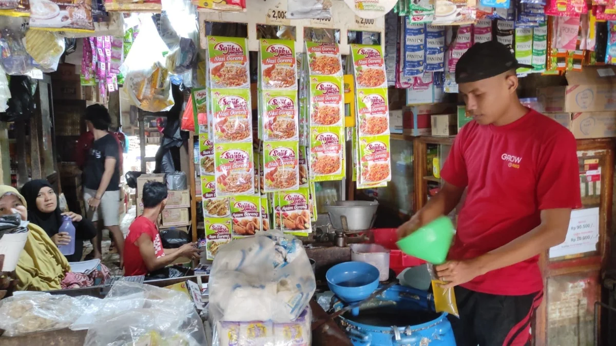 NAIK HARGA. Seorang pedagang sedang mengemas minyak goreng curah. Pedagang dan pelaku UMKM mengeluhkan kenaikan harga minyak goreng.