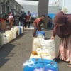 ANTRE. Warga sekitar Kecamatan Cigasong mengikuti operasi pasar minyak goreng curah, yang dijual dengan harga Rp14.000 per liter di halaman kantor Kecamatan Cigasong, Kamis (31/3).