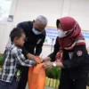 SIMBOLIS. Bupati H Acep Purnama secara simbolis menyerahkan bingkisan santunan kepada puluhan anak yatim di sela kegiatan APel yang digelar BKPSDM Kabupaten Kuningan, kemarin (7/4).