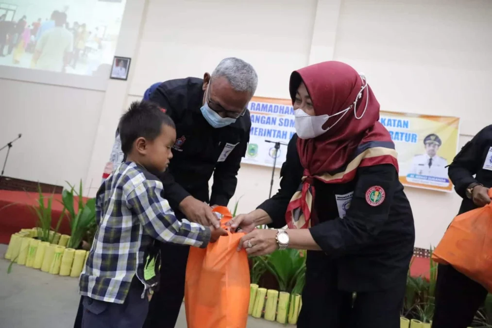 SIMBOLIS. Bupati H Acep Purnama secara simbolis menyerahkan bingkisan santunan kepada puluhan anak yatim di sela kegiatan APel yang digelar BKPSDM Kabupaten Kuningan, kemarin (7/4).