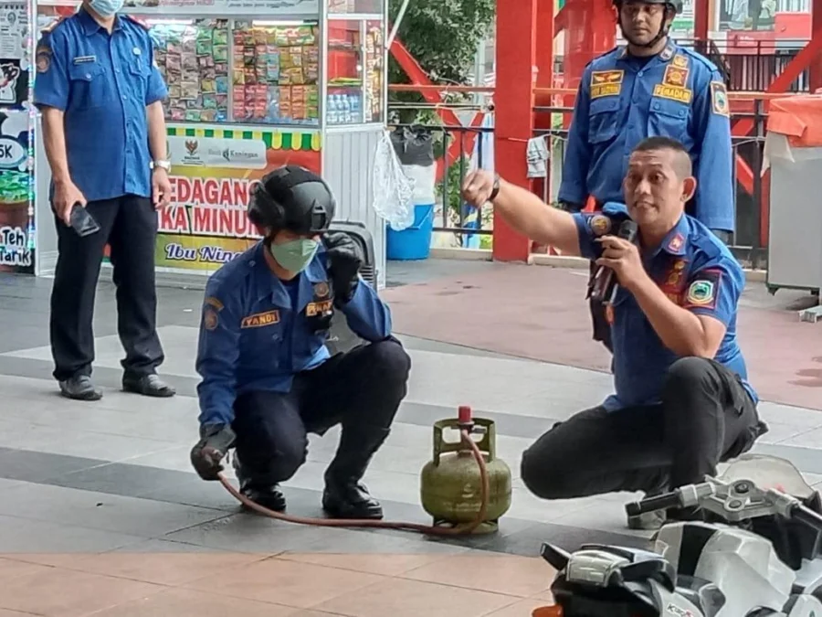 GELAR SIMULASI. Kepala UPT Damkar Satpol PP Kuningan, M Khadafi bersama anggotanya melakukan simulasi pemadaman api di halaman foodcourt kepada para pedagang setempat.