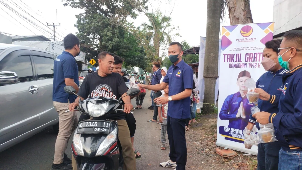 SEBAR TAKJIL. Ketua DPD NasDem Kabupaten Cirebon, Asep Zaenudin Budiman saat memberikan takjil kepada para pengguna jalan.