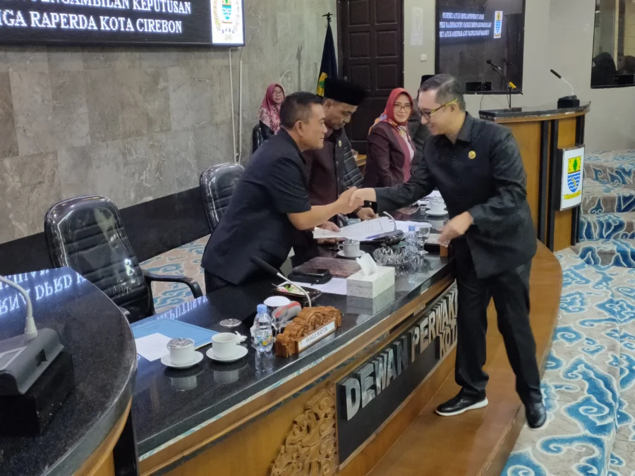 PERDA KEOLAHRAGAAN. Ketua Pansus Raperda Penyelenggaraan Keolahragaan, Andi Riyanto Lie menyerahkan draf raperda yang disetujui menjadi Perda Keolahragaan kepada Walikota Cirebon, Drs H Nashrudin Azis SH pada agenda paripurna, Senin 20 Februari 2023. FOTO: ASEP SAEPUL MIELAH/RAKYAT CIREBON