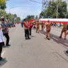 PENGHORMATAN. Salah seorang warga Kota Cirebon, mempunyai cara tersendiri untuk menghormati bendera pusaka merah putih sepanjang 500 meter yang dibawa pasukan gabungan pada Kirab Merah Putih, Senin  6 Maret 2023. FOTO: ASEP SAEPUL MIELAH/RAKYAT CIREBON