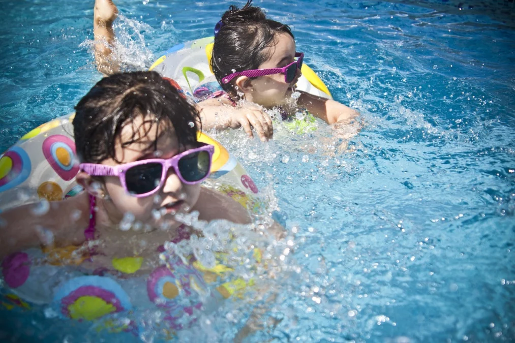 Dua anak pengunjung sedang berenang menggunakan ban di kolam renang. The Mountain Recreation Park Kuningan Cocok Buat Wisata Kolam Renang Keluarga. Foto: pixabay.com