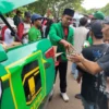 Ketua PAC PPP Kejaksan, yang juga Caleg DPRD Kota Cirebon, Hendi Irawan membagikan air minum kepada para peserta kampanye terbuka Ganjar-Mahfud diluar arena. FOTO: ASEP SAEPUL MIELAH/ RAKCER.ID