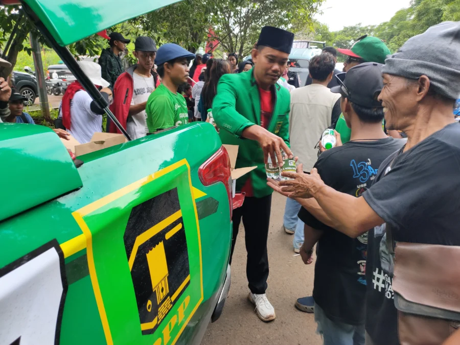 Ketua PAC PPP Kejaksan, yang juga Caleg DPRD Kota Cirebon, Hendi Irawan membagikan air minum kepada para peserta kampanye terbuka Ganjar-Mahfud diluar arena. FOTO: ASEP SAEPUL MIELAH/ RAKCER.ID